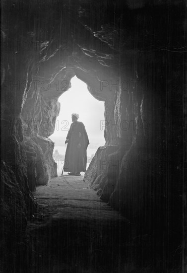 Man standing at the entrance to the Great Pyramid ca. 1900