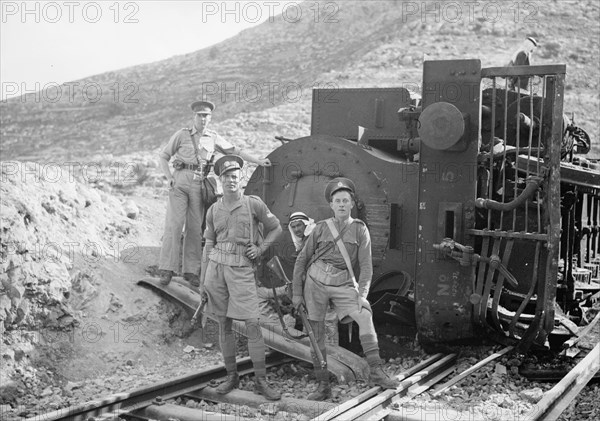 Soldiers stand in front of a wrecked train engine near Deir esh-Sheikh ca. between 1934 and 1939