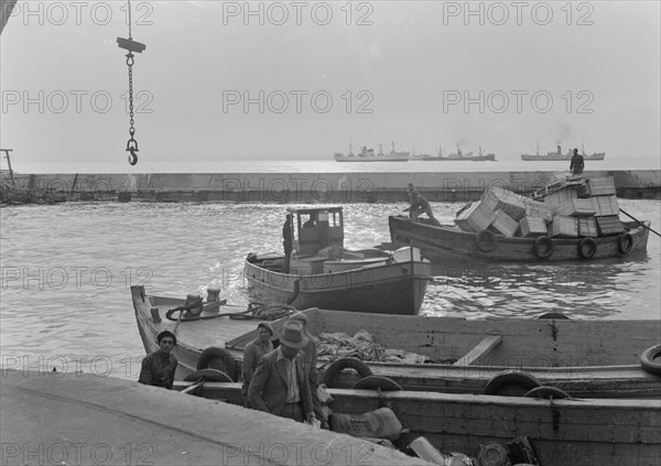 Boats in Tel Aviv Harbor. Setting sun, looking across lighter basin ca. 1939