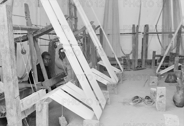 Workers at a native weaving establishment in Majdel village ca. between 1934 and 1939