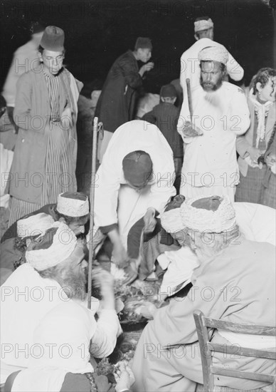 A Samaritan high priest and his family eating the Passover sacrifice on Mt. Gerizim ca. 1900