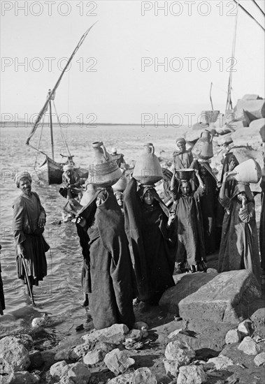 Native women with jars carrying water from the Nile somewhere in Egypt ca. 1900