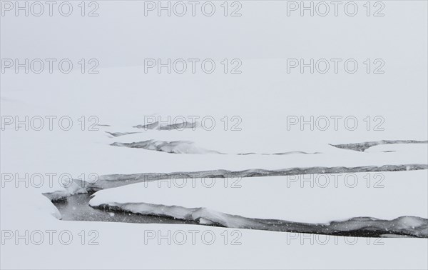 A creek winds through a snowy valley. Antler Creek in Hayden Valley in Yellowstone National Park; Date: 3 February 2015