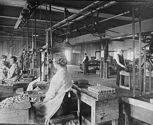 Men and women working at the Express Spark Plug Company ca.  between 1910 and 1926