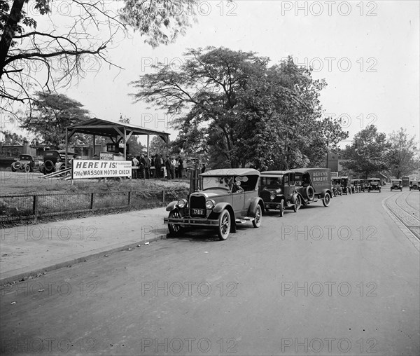 Early 1900s cars and trucks in a line, waiting for a Wasson Motor Check sponsored by the Havoline Oil Company ca.  between 1910 and 1935