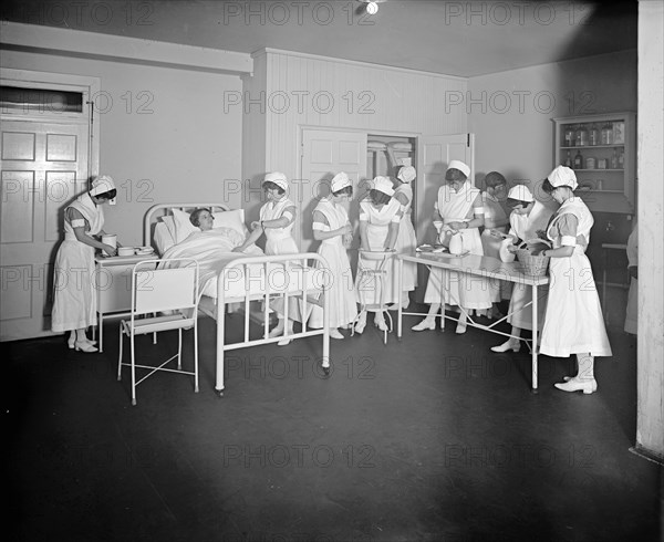 Nurse taking the pulse of a patient at the Homeopathic Hospital, [Washington, D.C.] ca.  between 1910 and 1926