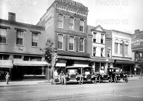 Cars parked outside electrical and atuo supply shops ca.  between 1910 and 1935