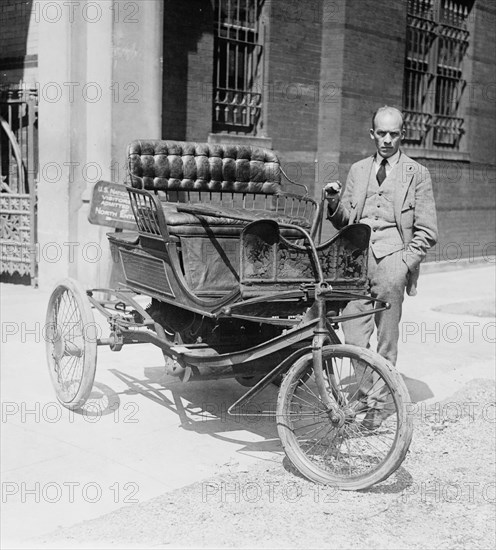 Carl W. Mitman, Curator of Engineering of the Smithsonian Institution photographed with a three-wheel automobile which has been recently acquired by that institution ca. 1924
