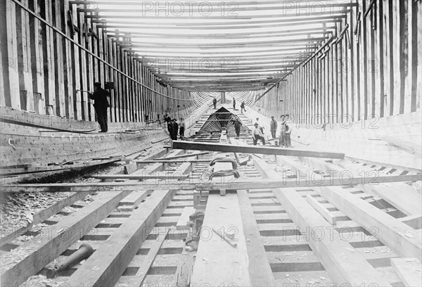 Workers building a wooden ship ca. between 1909 and 1920