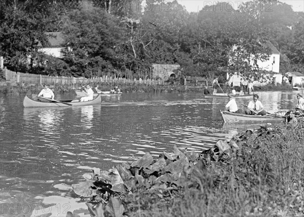 Men in boats and canoes on the C&O Canal ca. between 1909 and 1919