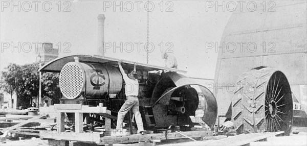 Workers in Buenos Aires, Argentina unpakcing and erecting an American tractor ca. between 1909 and 1920