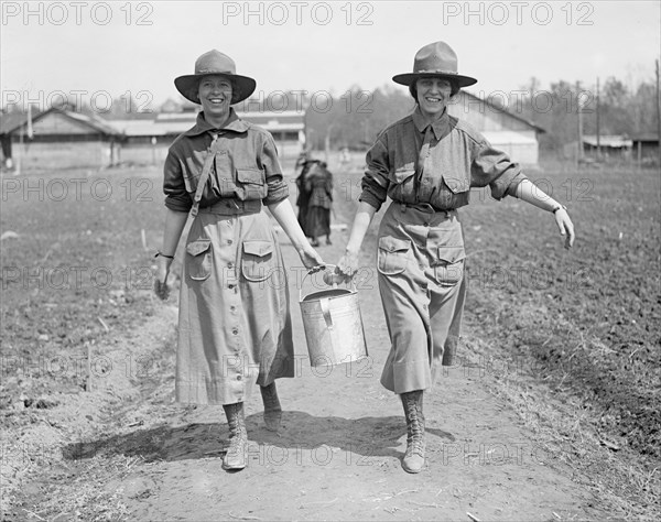 Two women carrying water at a National Women's Defense League camp ca. between 1909 and 1923