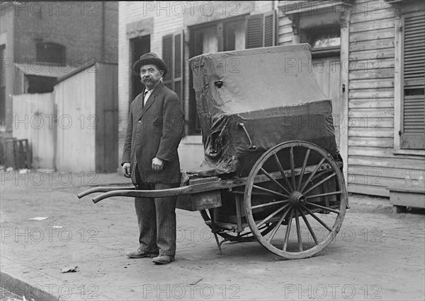 Organ grinder and his cart ca. between 1909 and 1940