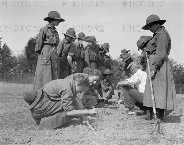 National Women's Defense League Camp: women planting seeds in a garden ca. between 1909 and 1923