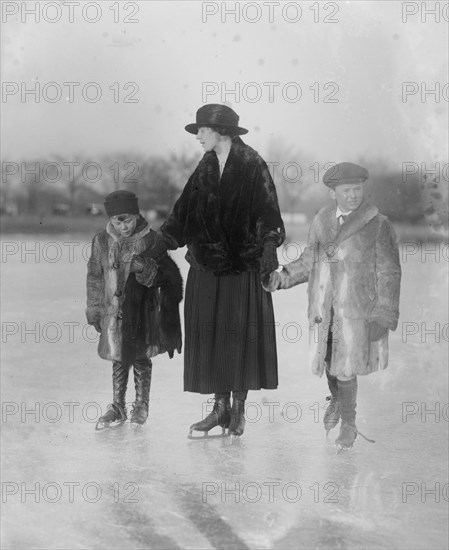 Mother and children ice skating outside ca. between 1918 and 1920