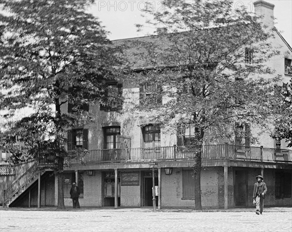 African American man walking across the street in SW Washington, D.C. ca.  between 1918 and 1920