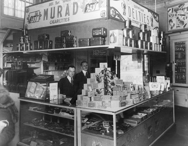 Interior of People's Drug Store, 7th and K Streets, Washington, D.C., with employees behind counter with display of smoking products including pipes, cigars, tobacco, and cigarettes ca. between 1909 and 1932