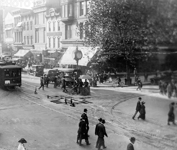 Street scene showing people, a streetcar, automobiles and buildings at the corner of a Washington, D.C. street. ca. [between 1909 and 1920]