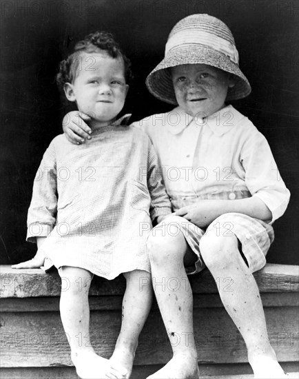 Two children, seated on step ca. 1909