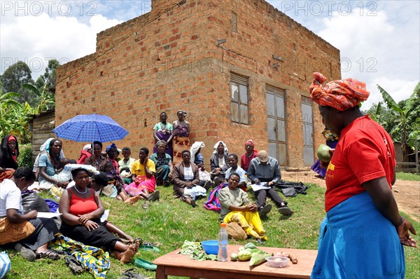 Lydia, a Family Life School group facilitator in the Bulambira community in Uganda teaches during a food demonstration at a group meeting ca. 14 March 2018