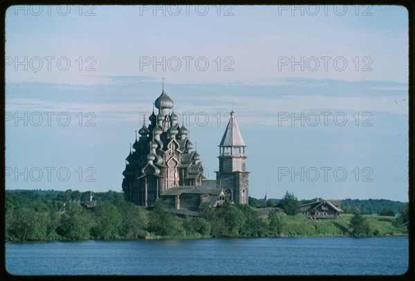 Pogost ensemble, Church of the Transfiguration (1714), and bell tower (19th century), northwest view, evening, Kizhi Island, Russia; 1993