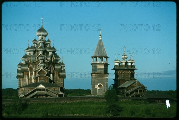 Pogost ensemble, Church of the Transfiguration (1714) (left); bell tower (19th century); Church of the Intercession (1764), west view, evening, Kizhi Island, Russia; 1993