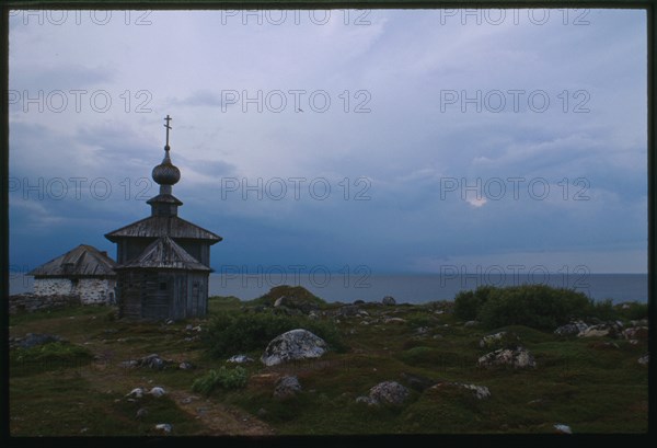 Church of St. Andrew (1702), east view, with stone dwelling (mid 16th century), and White Sea in background, Bol'shoi Zaiatskii Island, Russia; 1999