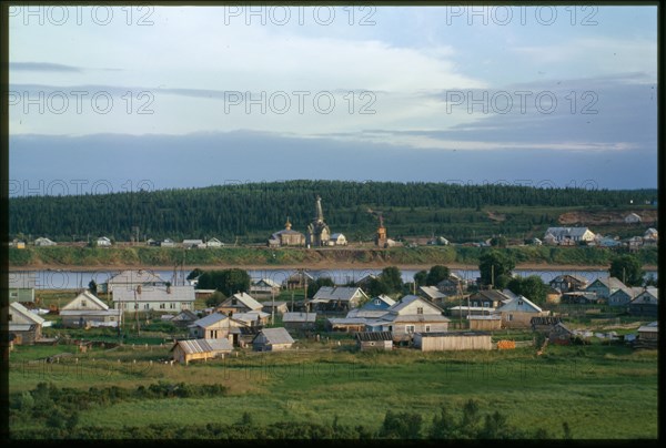 Southwest view, with village on left bank of Varzuga River in foreground, and Church of the Dormition (1674), beyond river in background, Varzuga, Russia; 2001