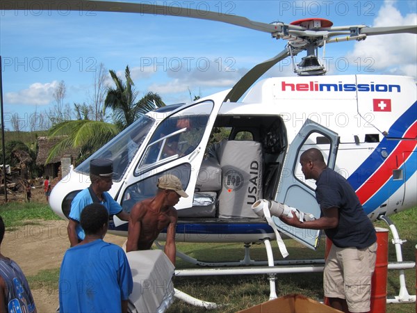 Aid workers load plastic sheeting rolls on a helicopter for those affected by the Giovanna cyclone in eastern Madagascar ca. 16 February 2012