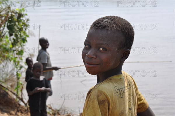 A boy and his friends enjoy some fishing on the bank of Vinho River near Vinho village at Gorongosa National park in Mobamzique ca. 23 April 2013