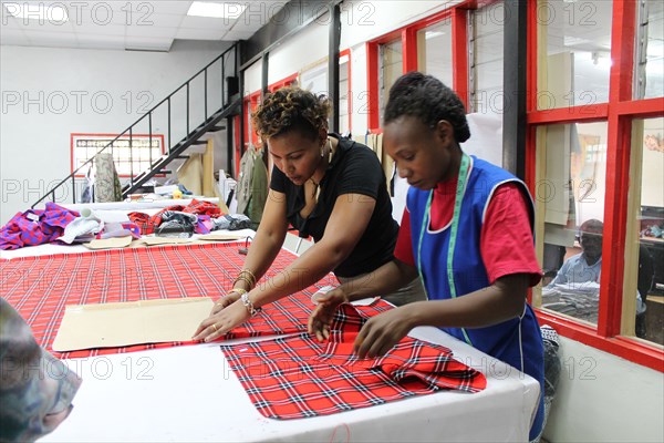 Woman working on Masai fabrics which are hand cut in preparation for custom made Doreen Mashika handbags. Each of these products are designed, manufactured, and produced by Africans, possibly in Kenya or Tanzania ca. 5 March 2014