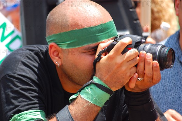 Photographer takes photos of Iranians in Texas taking part in a Freedom for Iran / Green Revolution rally at Dallas City Hall plaza in downtown Dallas, TX ca. June 2009