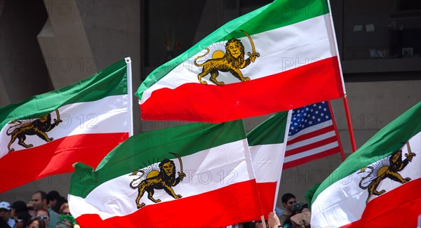 Iranians in Texas taking part in a Freedom for Iran / Green Revolution rally at Dallas City Hall plaza in downtown Dallas, TX; Iranian flags waving in the wind ca. June 2009