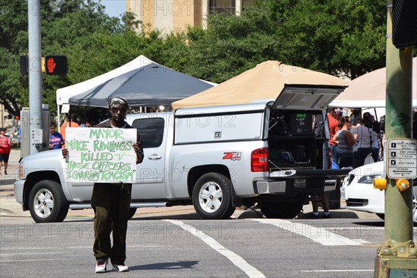 Dallas, Texas, USA. 10th July, 2016 An African American man holds a counter protest sign at a gathering of citizens in front of Dallas police headqurters who have come to show support for the police