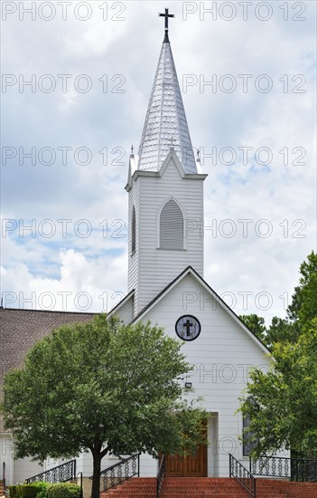 White church building with a tall steeple north of Brenham, TX