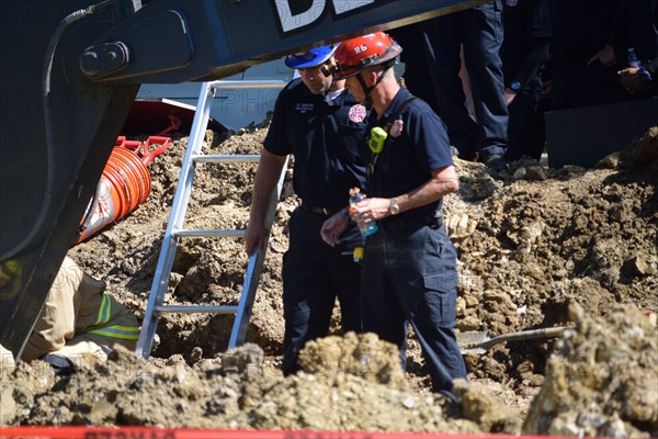 First responders; firemen and paramedics, help trapped construction worker trapped in a trench; Irving, TX USA