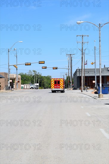 An ambulance stopped at a red traffic light in Commanche, TX