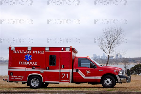 Ambulance from the Dallas TX fire department, parked next to White Rock Lake, Dallas skyline in the background