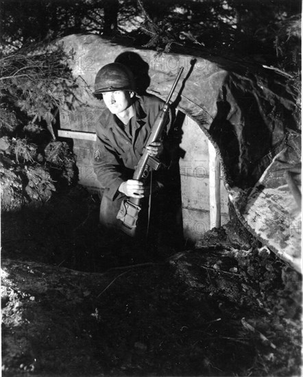 Tec 4 Fred Parke emerges from a dugout in Belgium