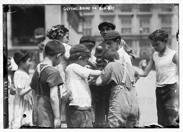 Youngsters around a water fountain on a hot day, c1911