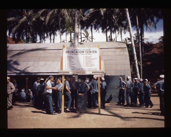 Sailors gathered around the center's sign, 1944