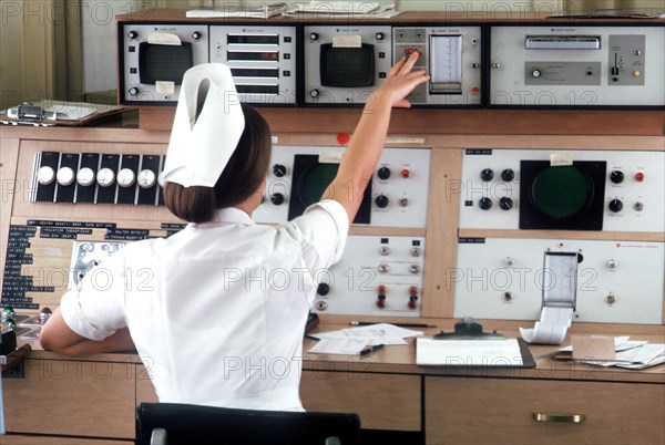 a nurse checks cardiac monitors.