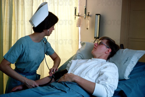 A US Army nurse takes a patient's blood pressure.