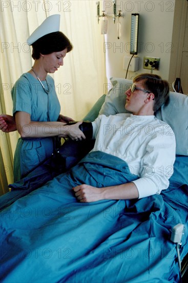 A US Army nurse takes a patient's blood pressure.