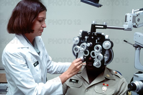 A female U.S. Army optometrist conducts a vision test.