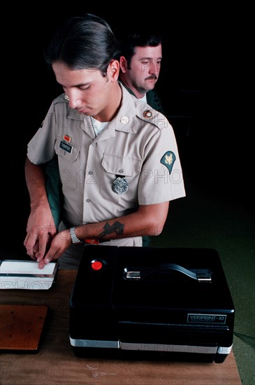 A US Army military policeman takes fingerprints.