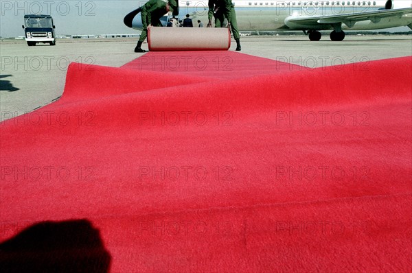 Airmen place a red carpet on the ground
