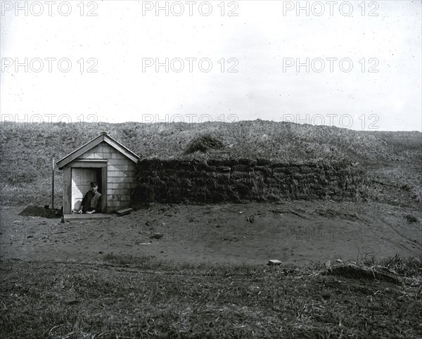 Partially Underground Structure With Man in Doorway