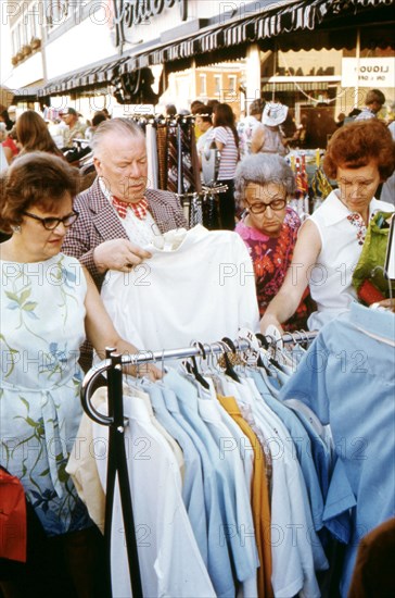 Adults Looking over Bargain Merchandise Placed in the Street