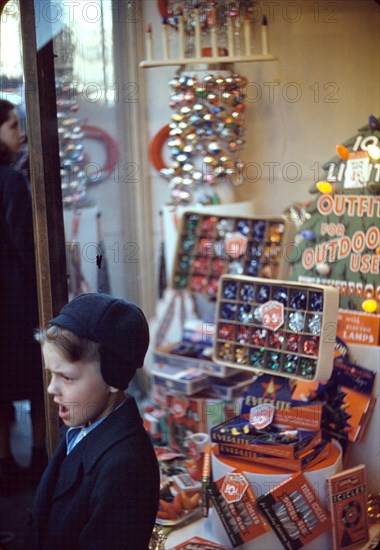 Boy beside store window display of Christmas ornaments